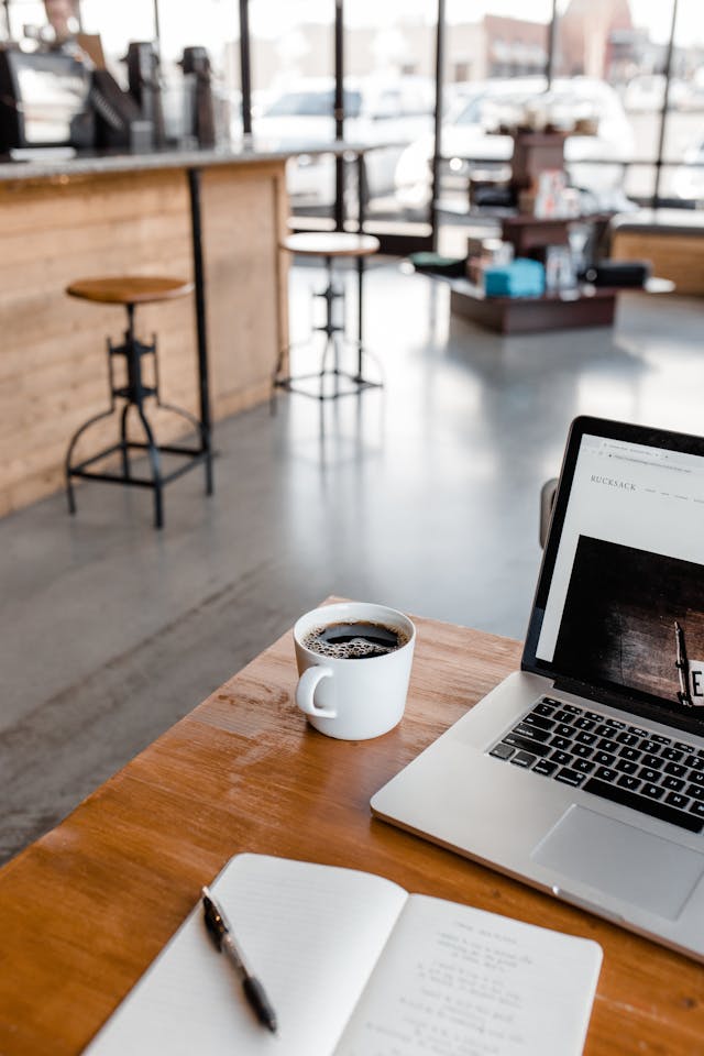 Cozy Coffee Shop Workspace with Laptop and Journal